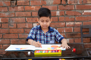 Indian schoolkid in uniform drawing and learning painting in classroom, Indian primary school education concept.