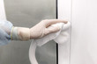 © Tatiana Dragunova - Cleaning door handles with alcohol. Infection protection. Gauze napkin in hand in medical glove