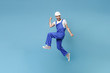 © ViDi Studio - Happy young man in coveralls protective helmet hardhat isolated on blue background studio. Instruments accessories for renovation apartment room. Repair home concept. Jumping, doing winner gesture.