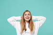 © ViDi Studio - Pretty young woman girl in casual white hoodie posing isolated on blue turquoise background studio portrait. People emotions lifestyle concept. Mock up copy space. Looking up with hands behind head.