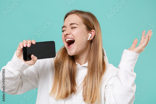 Fotografía Pretty young woman in casual white hoodie posing isolated on blue turquoise background in studio