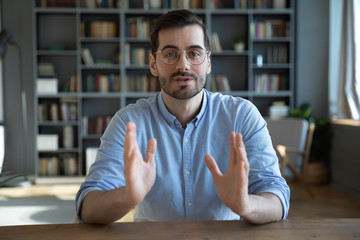 head shot portrait confident businessman coach wearing glasses looking at camera and talking, mentor