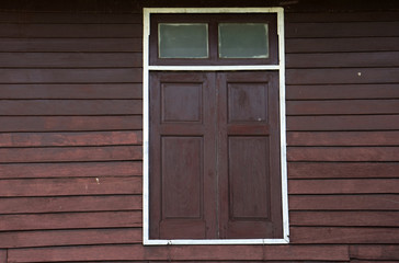 Single Traditional Dark Brown window with brown wood wall of traditional thailand house - vintage patterns - background