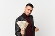 © luismolinero - Young man over isolated white background taking a lot of money
