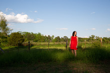 Woman In Red Dress In Sunlit Meadow