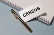 © valiantsin - CENSUS word on white paper with golden pen and white notepad on grey blue table