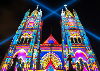 Wall Mural - The neo - gothic style Basilica of the National Vow (Basilica del Voto Nacional) illuminated with colorful lights during the Quito light festival.