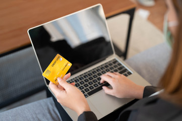 Young woman holding credit card using for online shopping,ordering,purchase in laptop