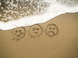 © shellygraphy - three smileys happy neutral and sad written in beach sand with ocean water foam in the background