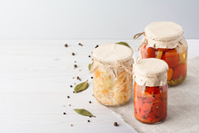 Various Pickled Fermented Cultured Vegetables In A Glass Jar For Canning On A White Table Whith Bay Leaf, Black Pepper, Coriander Seeds, Top View