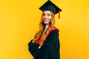 Wall Mural - Happy graduate, on a yellow background. Concept of the graduation ceremony
