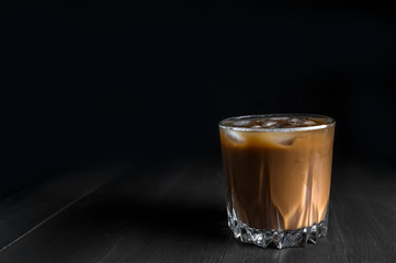 Wall Mural - Splash of ice coffee drink on a brown background. Cold beverage wave. Close-up design liquor milk, coffee and ice.