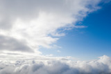 Fototapeta Niebo - Aerial view white clouds in blue sky. View from drone. Aerial top view cloudscape. Texture of clouds. View from above. Sunrise or sunset over clouds. Panorama clouds
