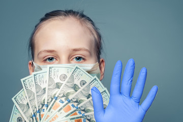 Wall Mural - Girl in medical face mask holding money cash US dollars and showing stop gesture on blue background