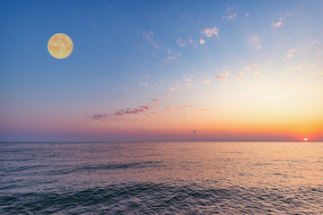 Moon above the sea at sunset time.