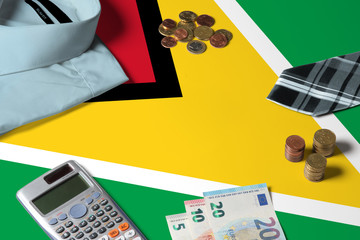 Guyana flag on minimal money concept table. Coins and financial objects on flag surface. National economy theme.