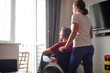 © sata_production - Woman helping disabled man in wheelchair at home