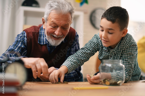 Fotografía Grandpa and grandson saving money