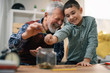 © JustLife - Grandpa and grandson saving money. Grandfather teaching grandchild how to save money.