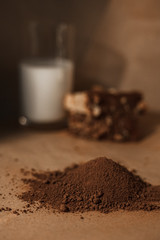 Chocolate muffins with milk on a dark background. Cocoa powder, chocolate muffin and a glass of milk