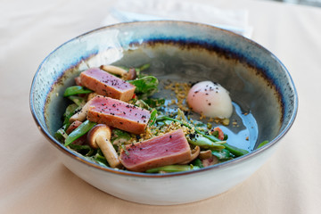 Wall Mural - Seared tuna steak on green pea salad, clay plate