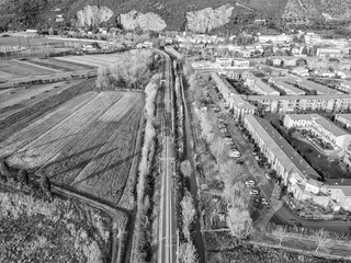 Wall Mural - Aerial view from the drone of the railway that runs along a small town in Tuscany