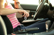 © bilanol - Close up of woman hand fastening seat belt while sitting inside a car for safety before driving on the road. Female driver driving secure and taking safe jorney.
