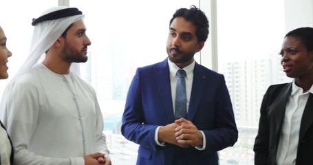 Wall Mural - Mixed business team in Dubai. Business meeting with men wearing kandura and western people in the office