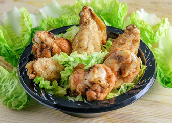 Fried chicken wings with fresh green lettuce prepared for eating. Fast food.