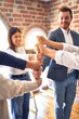 © Krakenimages.com - Group of business workers smiling happy. Standing bumping fists at the office