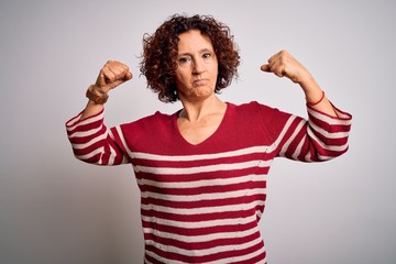 Sticker - Middle age beautiful curly hair woman wearing casual striped sweater over white background showing arms muscles smiling proud. Fitness concept.