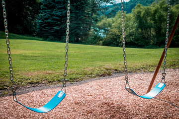 Wall Mural - Empty swings on a swingset at a park during the summer