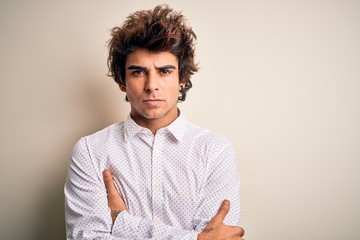 Sticker - Young handsome businessman wearing elegant shirt standing over isolated white background skeptic and nervous, disapproving expression on face with crossed arms. Negative person.