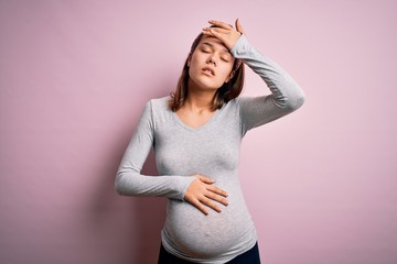 Wall Mural - Young beautiful teenager girl pregnant expecting baby over isolated pink background Touching forehead for illness and fever, flu and cold, virus sick