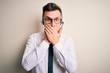 © Krakenimages.com - Young handsome caucasian business man wearing call center headset at customer service shocked covering mouth with hands for mistake. Secret concept.