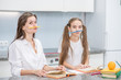 Happy woman and young girl are having fun and foolish while doing homework together