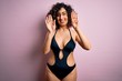 © Krakenimages.com - Young beautiful arab woman on vacation wearing swimsuit and sunglasses over pink background showing and pointing up with fingers number nine while smiling confident and happy.