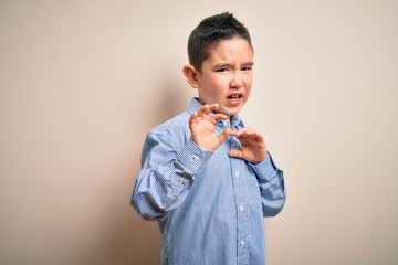 Sticker - Young little boy kid wearing elegant shirt standing over isolated background disgusted expression, displeased and fearful doing disgust face because aversion reaction. With hands raised