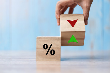 business man Hand change wood cube block with percentage to UP and Down arrow symbol icon. Interest rate, stocks, financial, ranking, mortgage rates and Cut loss concept