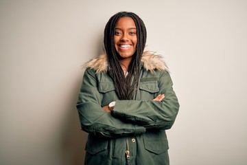 Canvas Print - Young african american woman wearing winter parka coat over isolated background happy face smiling with crossed arms looking at the camera. Positive person.