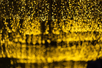 Wall Mural - many of bokeh from light bulb tube on a street at night that look like luxury golden star light in dark background