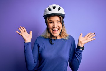 Poster - Young beautiful blonde cyclist woman wearing bike security helmet over purple background celebrating crazy and amazed for success with arms raised and open eyes screaming excited. Winner concept