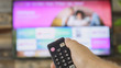 © RightFramePhotoVideo - Male hand holding the TV remote control and changing TV channels