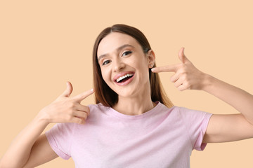 Wall Mural - Young woman with beautiful smile on color background