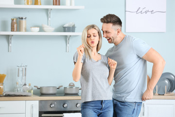 Poster - Happy dancing young couple in kitchen