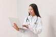 © Pixel-Shot - Female Asian doctor with laptop on light background