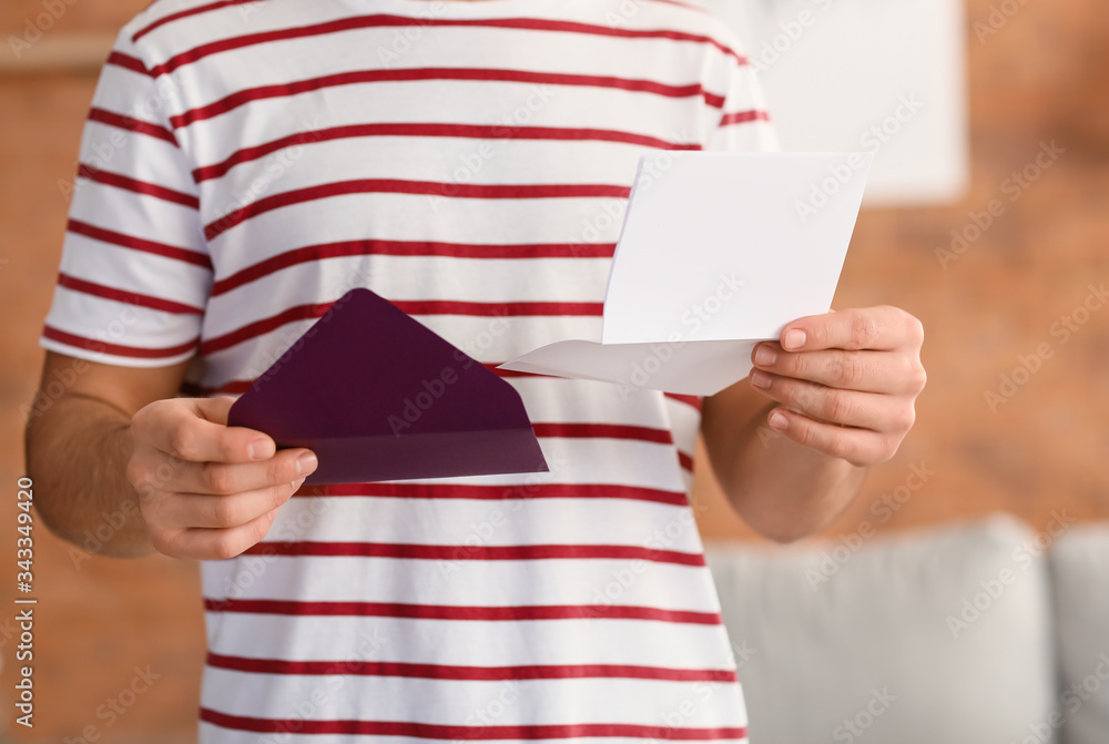 Young man with letter at home