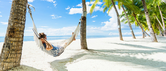 Man in hammock on the beautiful tropical beach. Banner.