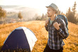 © Svetlana - Handsome bearded man tourist exploring new places on top of mountains. Hiker man in hat with backpack happy to see sunrise