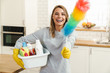 Photo of woman housewife holding cleanser bottles and colorful duster